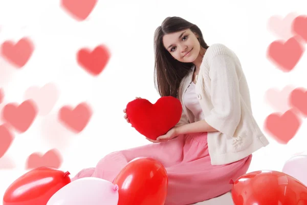 Jong meisje met rode ballonnen op hart-vormige bokeh — Stockfoto