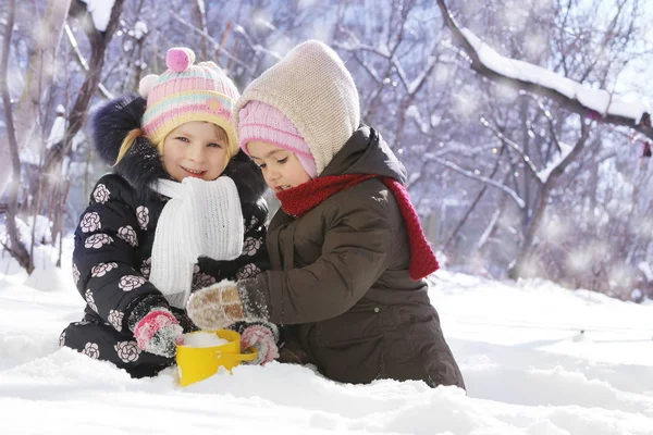 Happy girls playing in snowy park — Stock Photo, Image