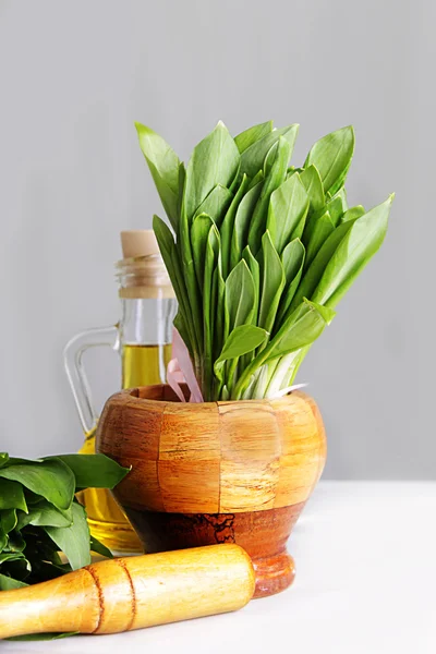 Fresh wild onion leaves in mortar and pestle — Stock Photo, Image