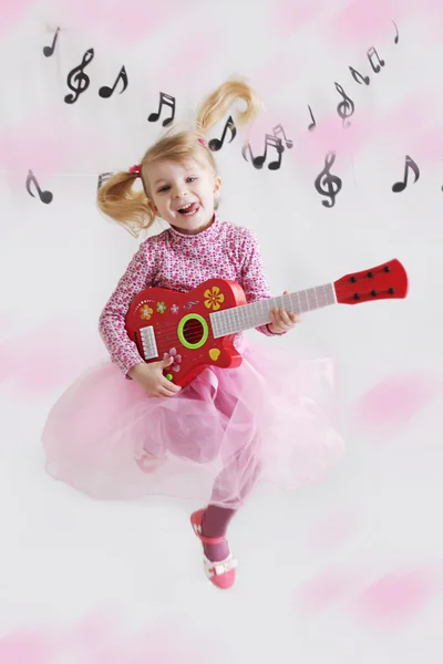 Menina com guitarra em notas de música fundo — Fotografia de Stock