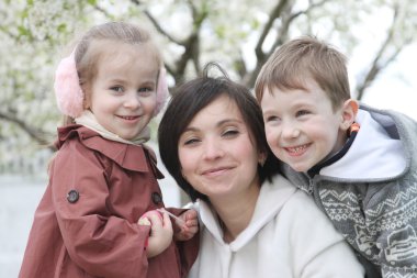 annesi ve iki çocuk arasında blooming Bahçe sarılma