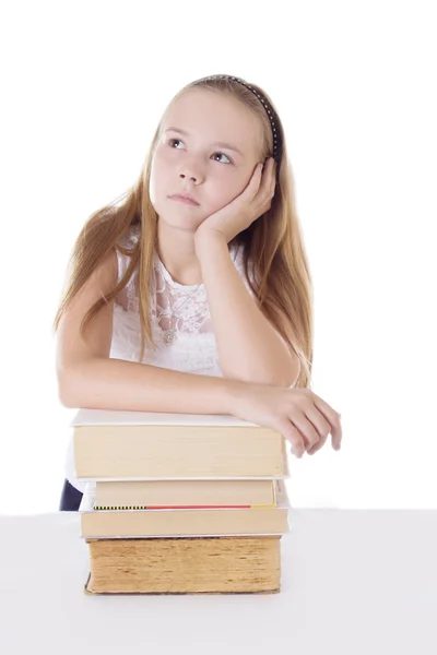 Doordachte schoolmeisje met stapel boeken — Stockfoto
