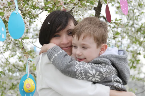 Matka a syn v rozkvetlé zahradě, dekorace na Velikonoce — Stock fotografie