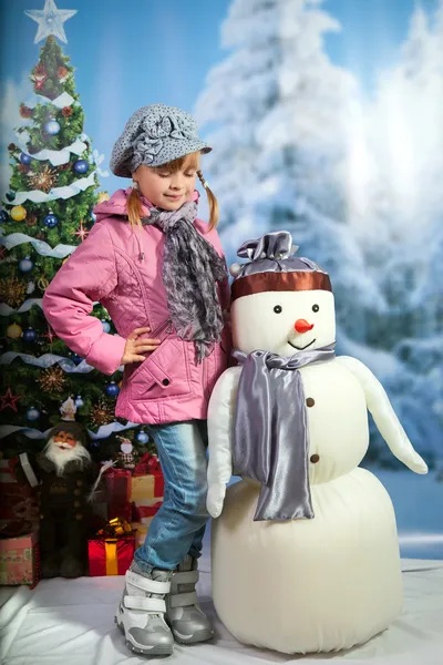 Девушка со снеговиком на фоне зимнего пейзажа — стоковое фото