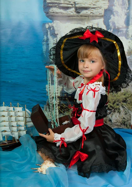 Menina bonito com uma caixa em suas mãos em um chapéu contra o mar — Fotografia de Stock