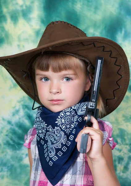 Egy gyönyörű lány, egy cowboy kalap fegyverrel portréja — Stock Fotó