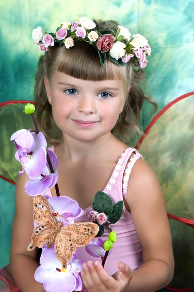 Όμορφο κορίτσι σε ένα ελαφρύ φόρεμα με φτερά σε ένα στεφάνι σε ένα gree — Φωτογραφία Αρχείου
