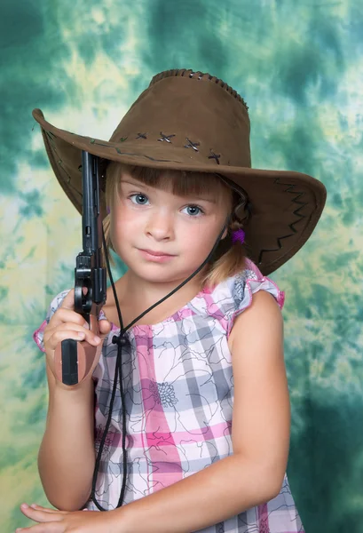 Porträt eines schönen Mädchens mit Cowboyhut und Pistole — Stockfoto