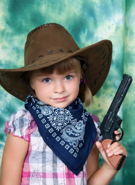 Portret van een mooi meisje in een cowboy hoed met een pistool — Stockfoto