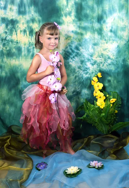 Beautiful girl in a pink dress with wings in a wreath on a green — Stock Photo, Image