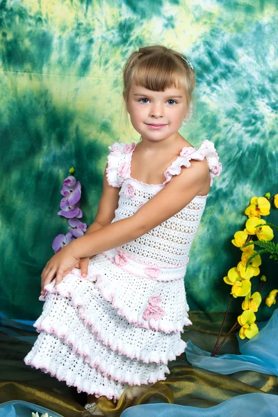 Mooi meisje in gebreide jurk met een groene achtergrond — Stockfoto