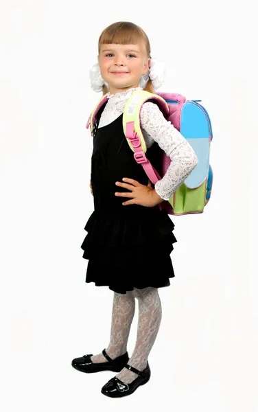 Studentessa in uniforme scolastica con uno zaino su uno schienale biancogr Fotografia Stock
