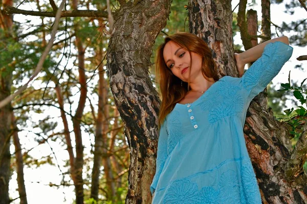 森の中の清掃着の青いドレスの若い女性 — ストック写真