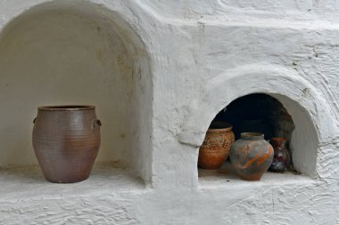 Çamur sürahileri eski bir kır sobasının üzerinde oturur..