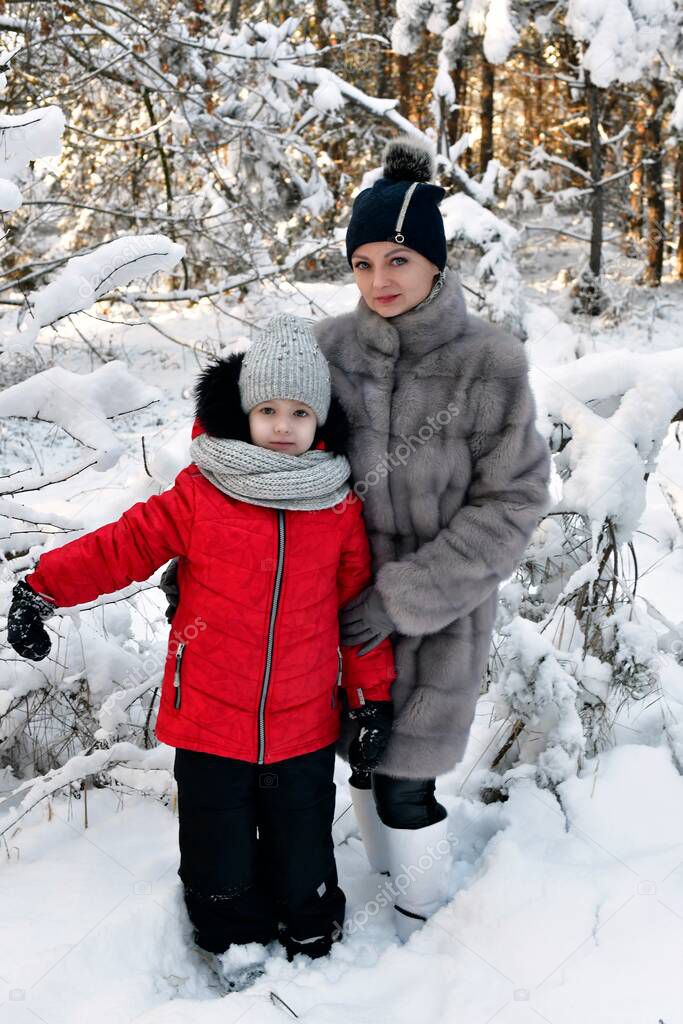 Walk mother and daughter girls in a beautiful, fabulous snowy forest.