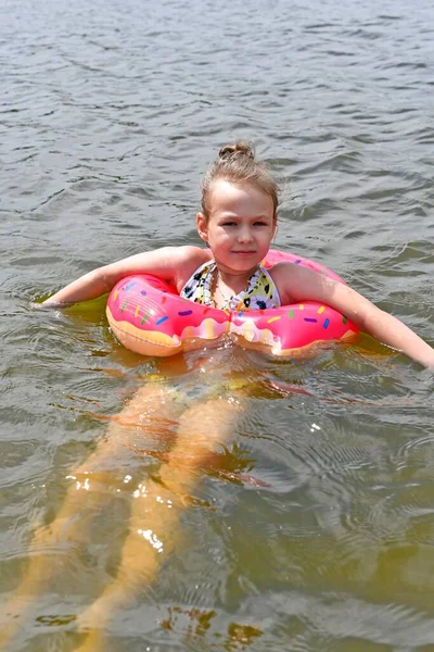 아름다운 소녀가 여름에 강에서 부풀어 오르는 위에서 수영을 — 스톡 사진