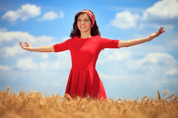 Kvinna med händerna upp upp i fältet vete — Stockfoto
