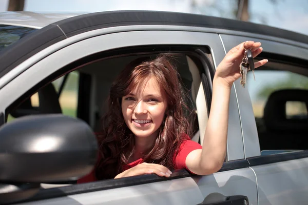Menina no carro mostrando chaves — Fotografia de Stock