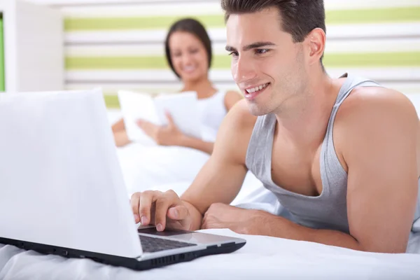 Happy couple relaxing in bed — Stock Photo, Image