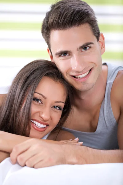 Pareja feliz abrazándose en la cama — Foto de Stock