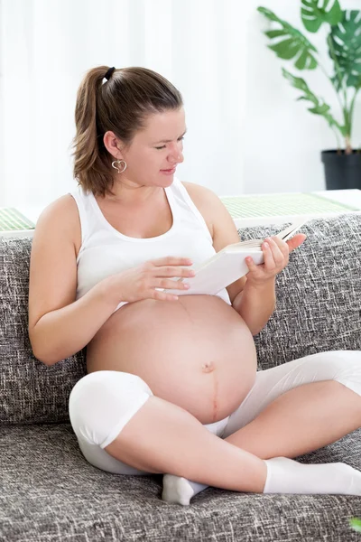 Zwangere vrouw lezing boek — Stockfoto