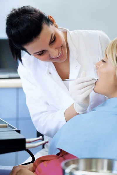 Dentista femenina examinando los dientes de la paciente — Foto de Stock