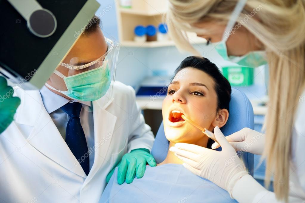 Dentist with nurse doing procedure on patient Stock Photo by ©luckybusiness 14355239