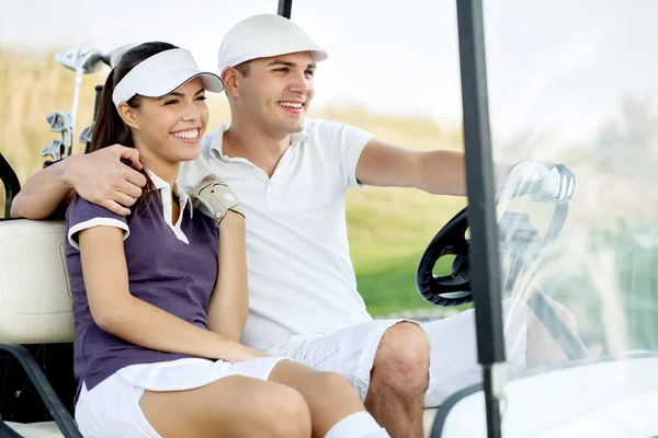 Pareja sonriente en carrito de golf — Foto de Stock