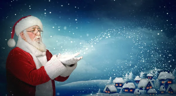 Santa claus waait sneeuw naar de kleine stad — Stockfoto
