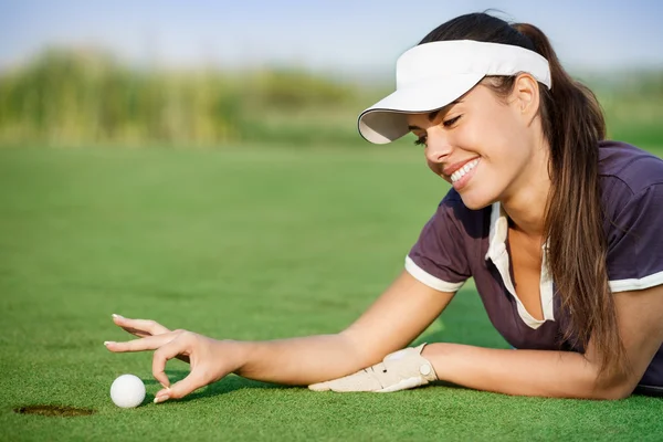 Mulher empurrando bola de golfe — Fotografia de Stock