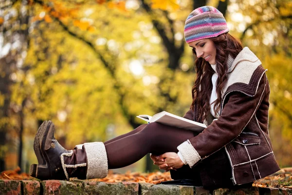 Mujer bonita leyendo libro y sonriendo —  Fotos de Stock