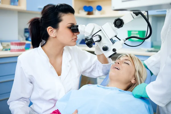 Dentist looking through microscope — Stock Photo, Image