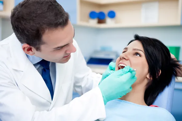 Zahnarzt arbeitet an den Zähnen des Patienten Stockbild
