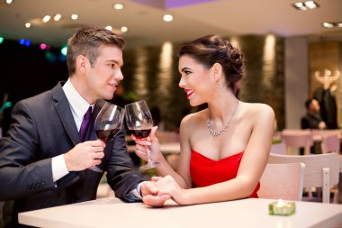 happy couple at restaurant table toasting