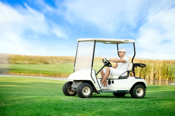 Giovane uomo guida golf buggy — Foto Stock