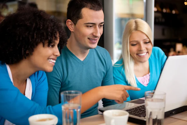 Studenti in caffè con computer portatile — Foto Stock