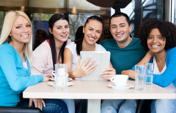 Smiling group of teenagers at cafe