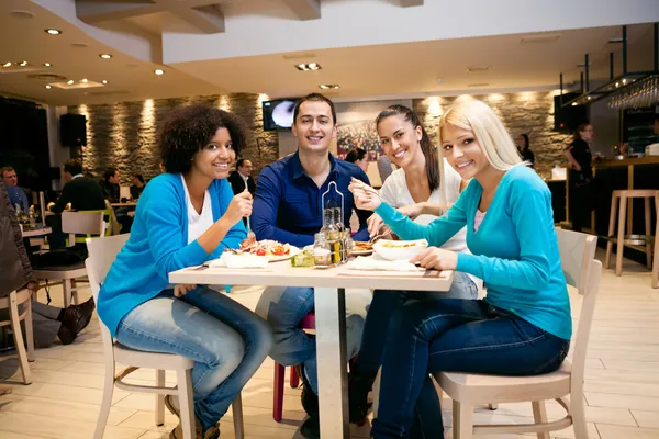 Jóvenes almorzando en restaurante — Foto de Stock