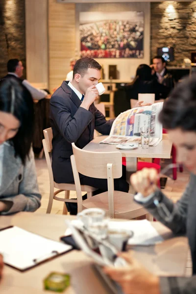 Joven empresario sentado a la mesa en la cafetería — Foto de Stock