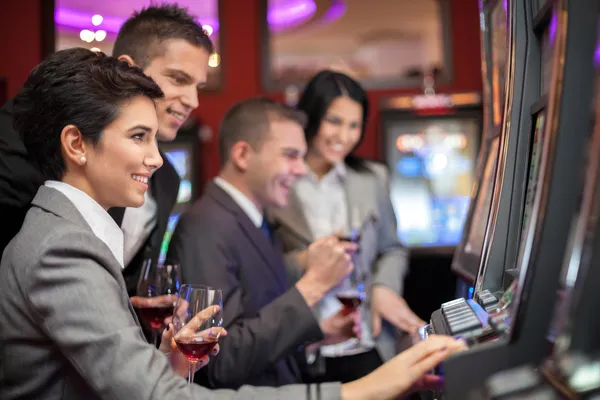 Jóvenes disfrutando de jugar a las máquinas tragaperras — Foto de Stock