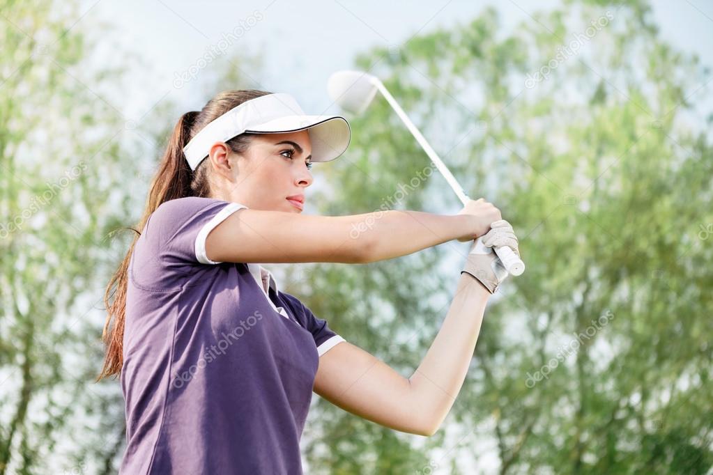 Woman playing golf, standing in pose after hit