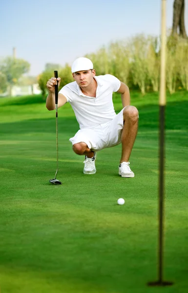 Jovem golfista alinhando um putt — Fotografia de Stock