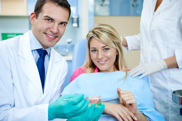 Dentista explicando un trabajo de dentadura postiza femenina — Foto de Stock