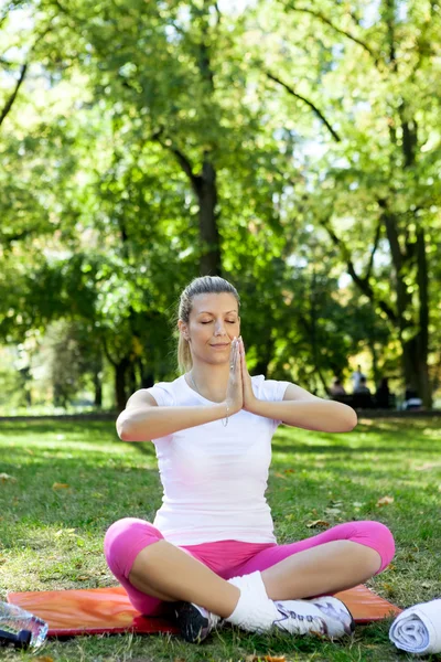 Молодая женщина медитирует в парке — стоковое фото