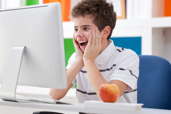 Niño sorprendido mirando la pantalla — Foto de Stock