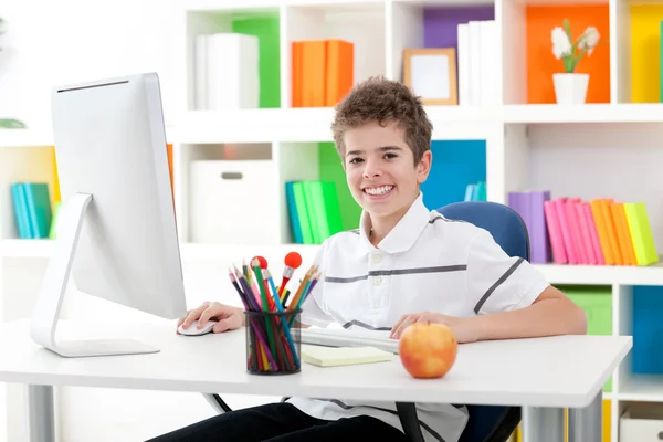 Smiling boy using a computer — Stock Photo, Image