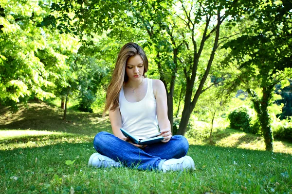 Woman reading book in the park — Stock Photo, Image