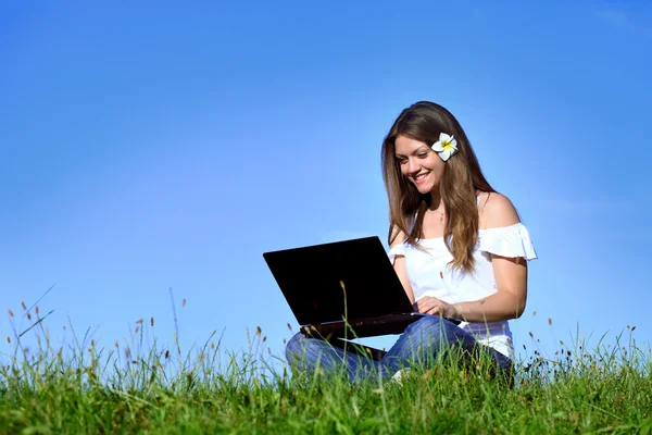 Uśmiechnięte dziewczyny za pomocą laptopa w przyrodzie — Zdjęcie stockowe