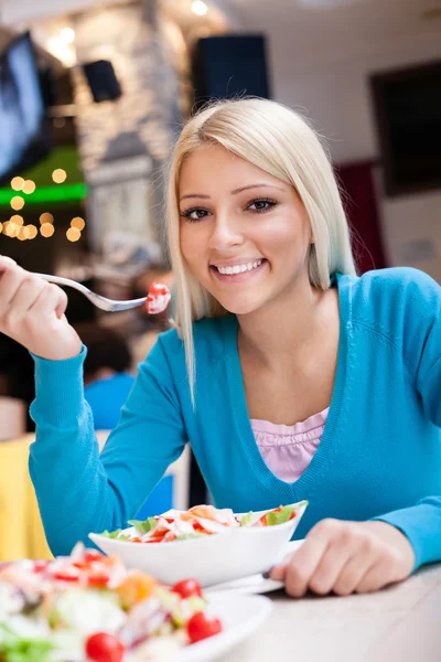 Mulher está comendo salada — Fotografia de Stock