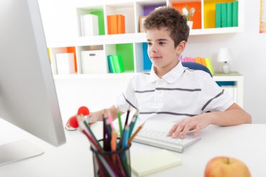 Smiling boy using computer clipart